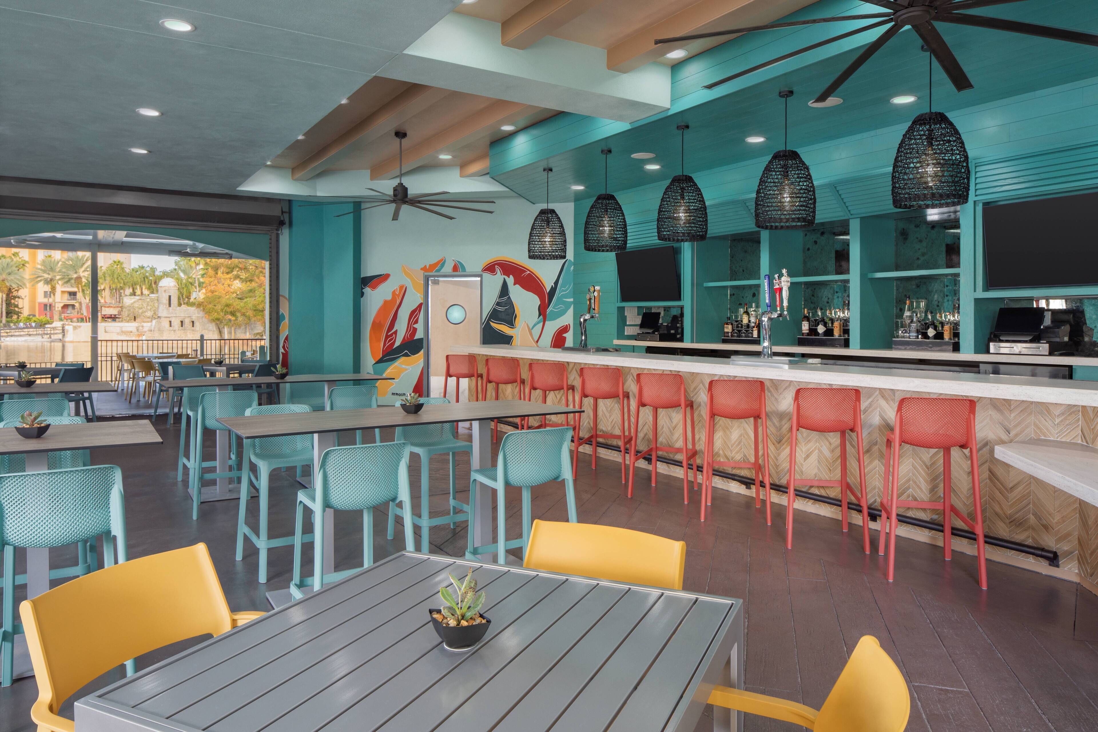 Un restaurante con terraza, barra y ventilador de techo.