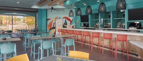 Un restaurante con terraza, barra y ventilador de techo.