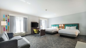 A hotel room with two beds, a desk, a chair, a TV, and a window with curtains.