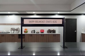 A breakfast area with a sign that reads "HAPPY BREAKFAST STARTS HERE."