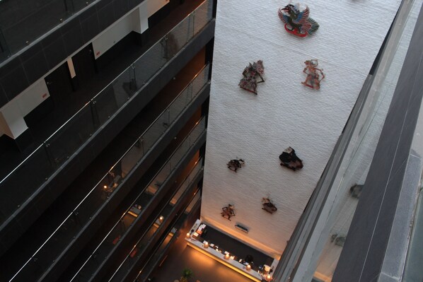 A high-rise building with multiple floors, a central atrium, and a rooftop with decorative elements.
