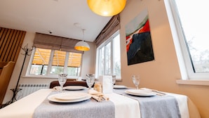 A dining area with a table set for two, featuring a white tablecloth, two wine glasses, a water glass, a napkin, and a salt and pepper shaker. - Chagala Uralsk Hotel (Uralsk)