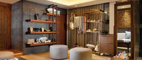 A modern living room with a sofa, ottomans, a coffee table, and a wooden bookshelf.