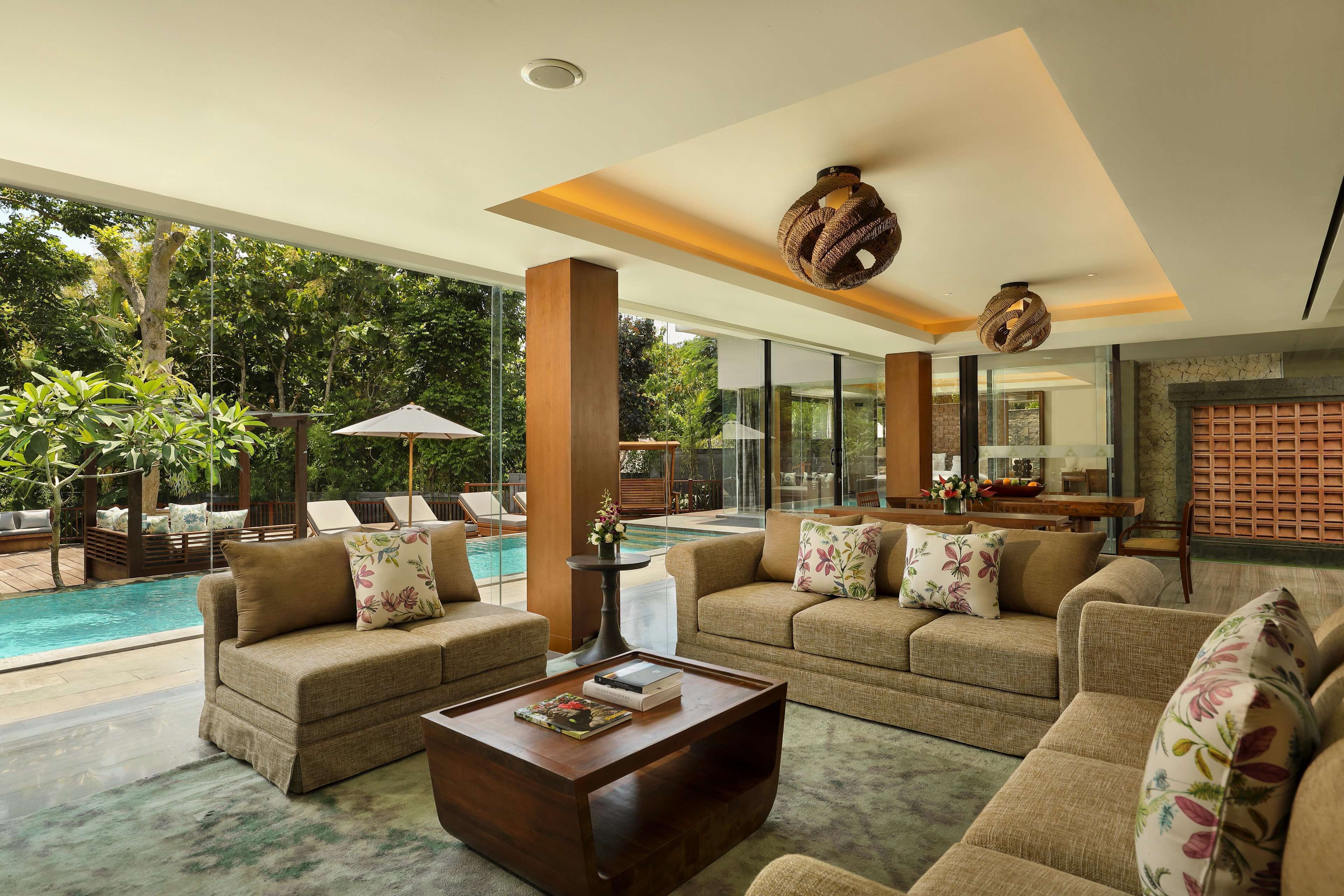 A spacious living area with a pool, comfortable seating, and a view of the outdoors.