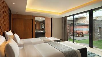 Habitación de hotel con dos camas, un baño y vista a un patio exterior.