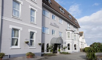 A hotel with a classic architectural style, featuring multiple windows and a central entrance with a canopy.