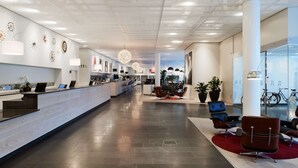 Una moderna zona de recepción con una larga barra de mostrador, área de descanso y decoración mural.