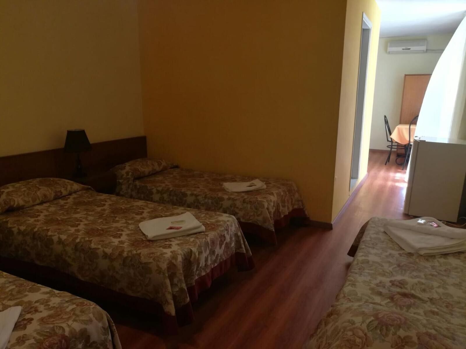 A hotel room with two beds, a desk, and a chair.