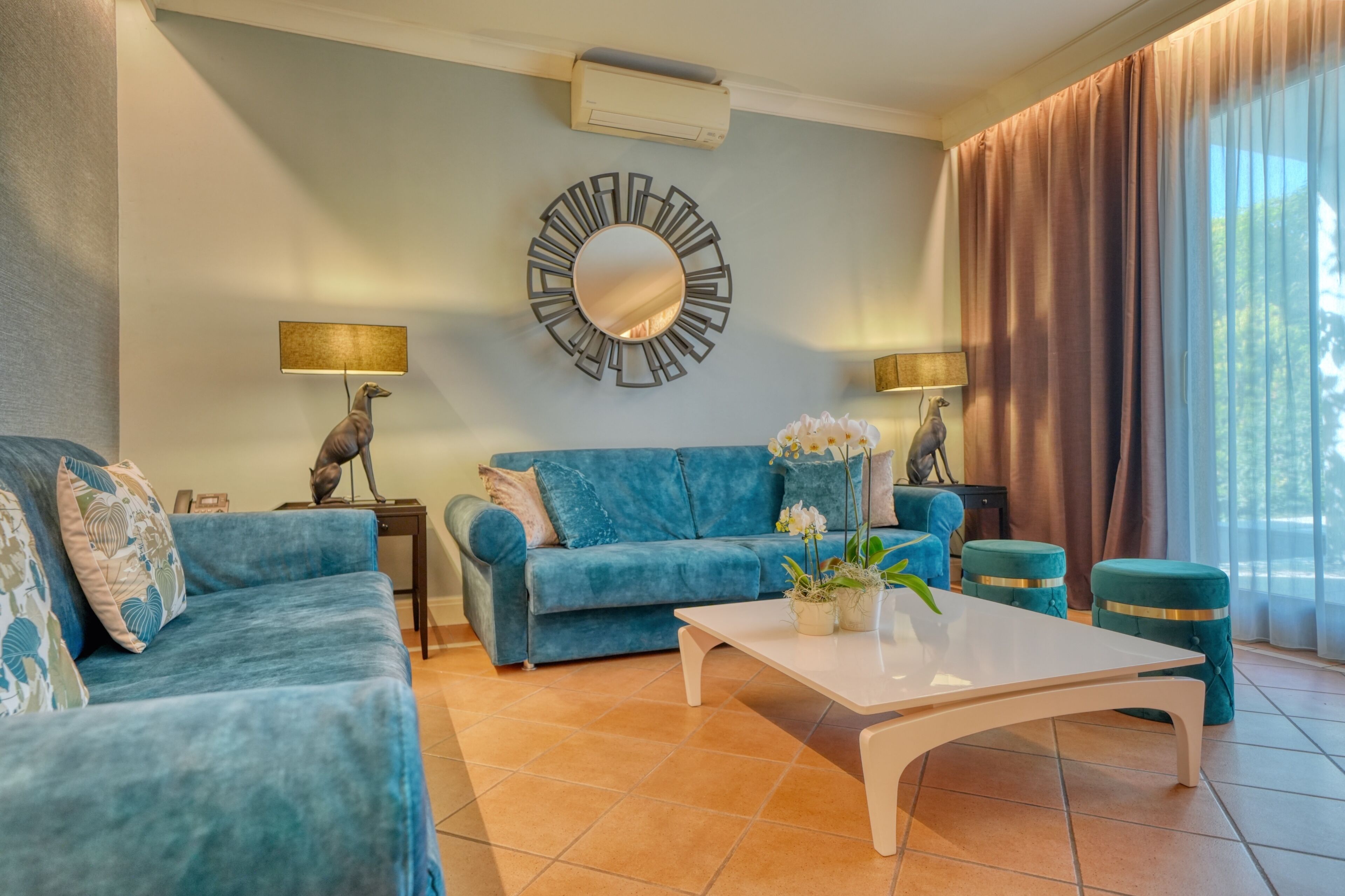 A living room with a blue sofa, a white coffee table, and two side tables with lamps.