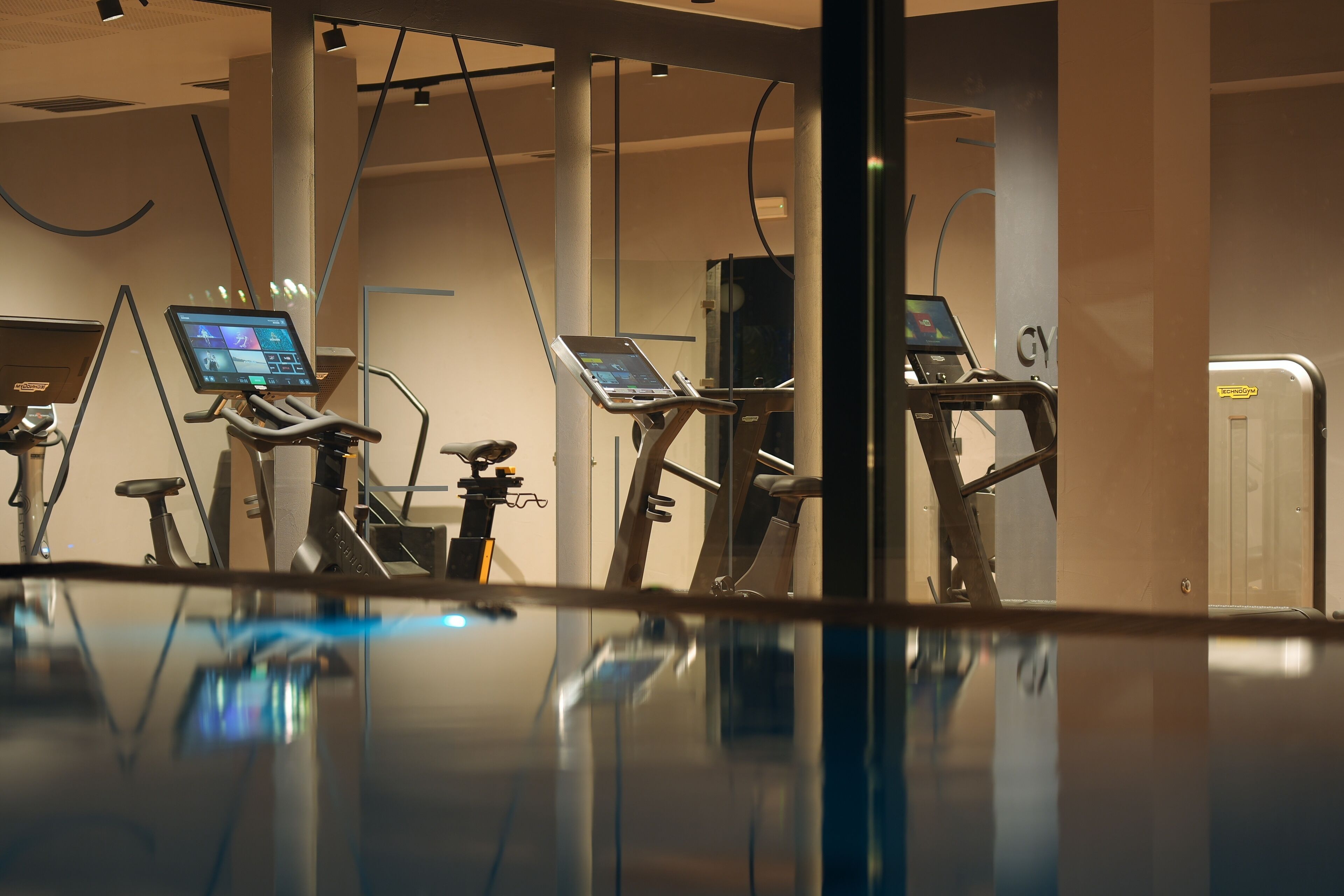 A gym with stationary bikes and a control panel.