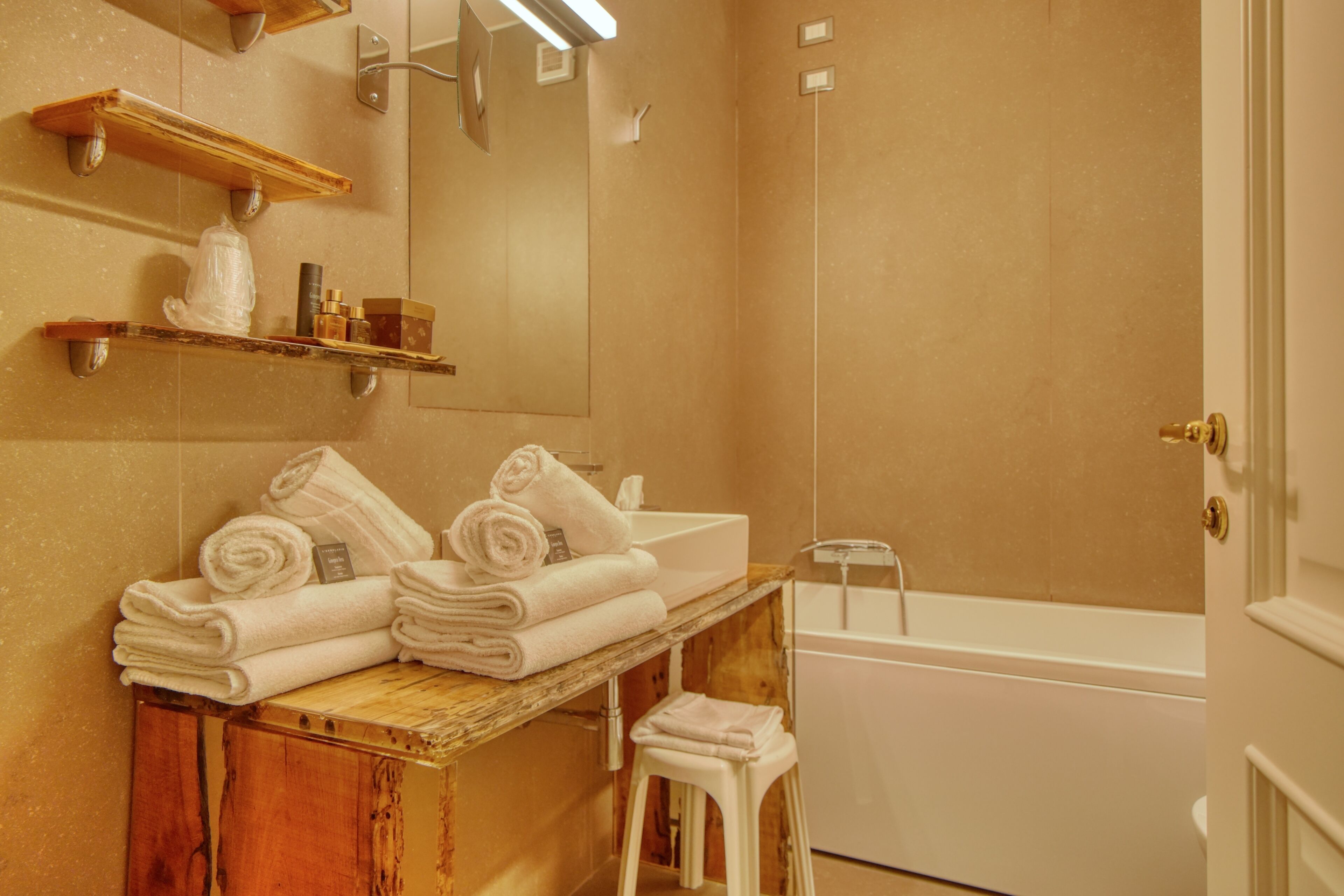 Ein Badezimmer mit Holzwaschtisch, Waschbecken, Spiegel und Badewanne.