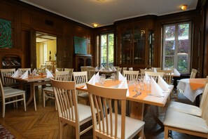 A dining area with wooden tables and chairs, set for a meal. - Hôtel Domaine de Volkrange (Thionville)