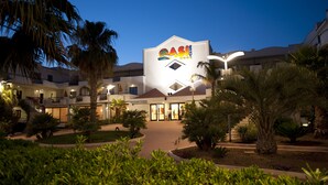 A hotel with a reception area, palm trees, and a well-lit entrance. - Oasiclub Hotel (Vieste)