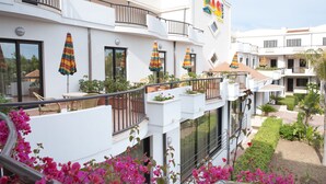 A hotel with multiple balconies, outdoor seating, and colorful umbrellas. - Oasiclub Hotel (Vieste)