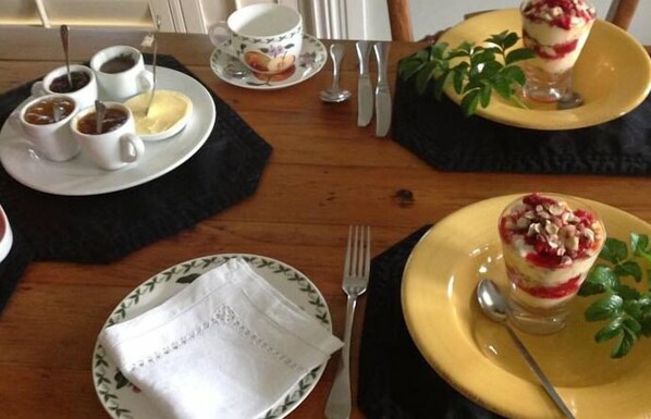A dining table set with plates, cups, and cutlery.