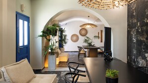 A modern interior with a dining area, a sofa, and potted plants.
