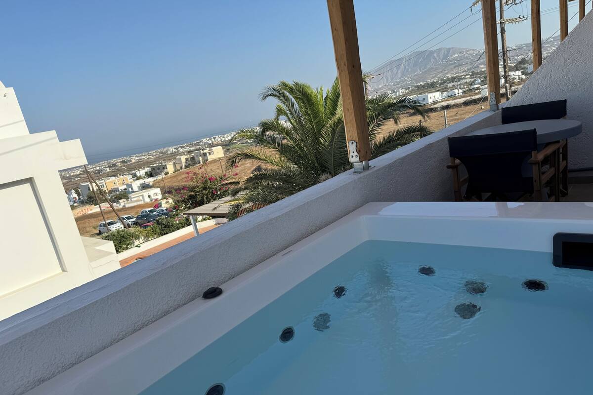 Piscina no terraço com vista para a cidade e montanhas.