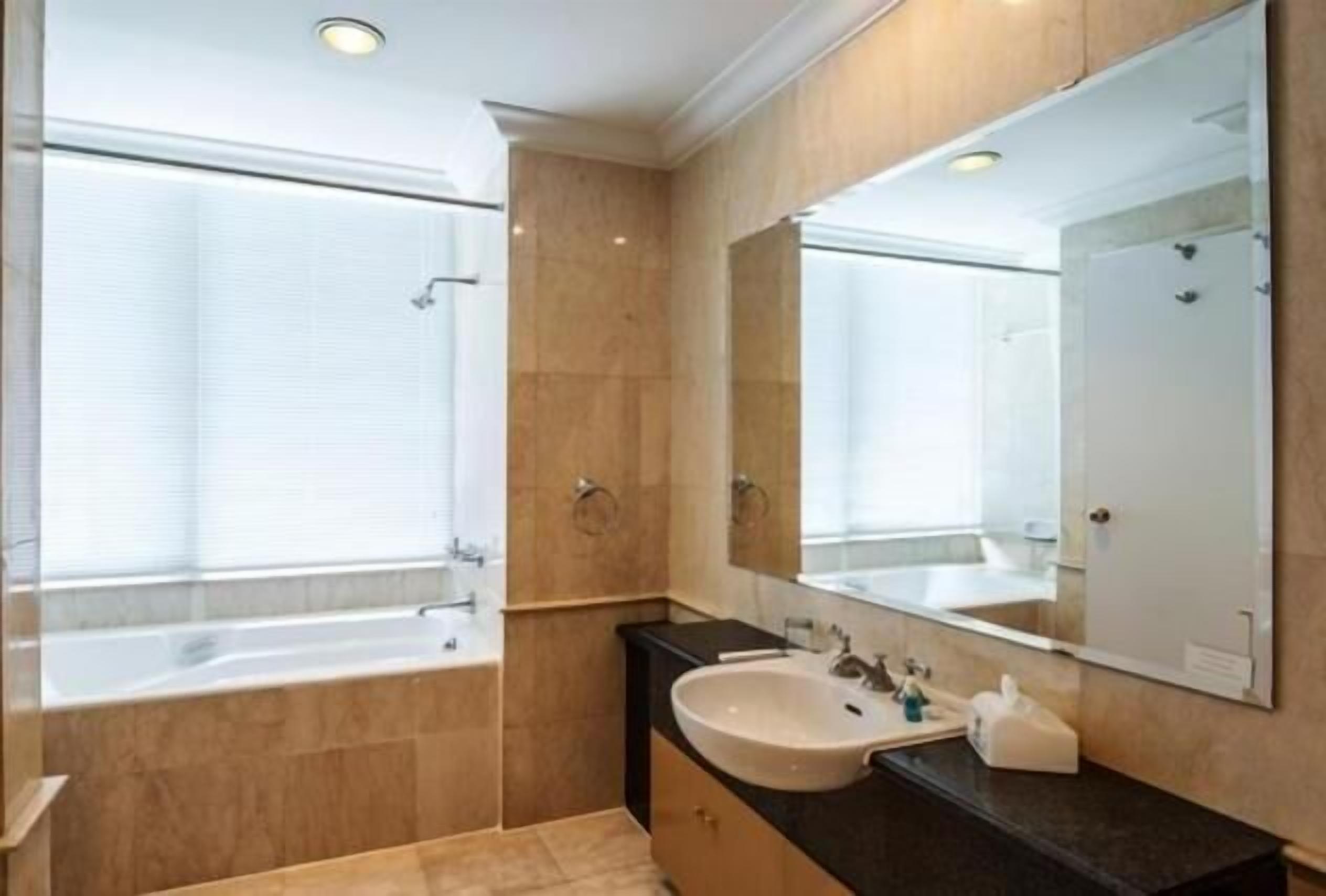 Une salle de bain moderne avec une baignoire, un lavabo et un grand miroir.