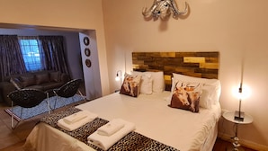 Une chambre d’hôtel comprenant un lit, un canapé, un coin repas et donnant sur l’extérieur.