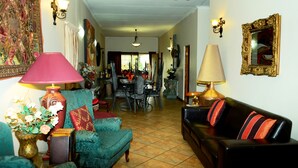 Un salon comprenant un coin repas, avec un canapé, des fauteuils, une table et des lampes.