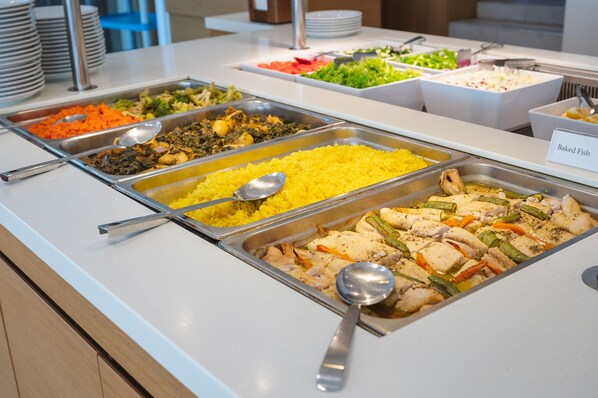 A buffet with various food options including yellow rice, baked fish, and mixed vegetables. - Silver Beach Hotel (Platanias)