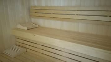 Una sauna con bancos de madera y un calentador para bancos.