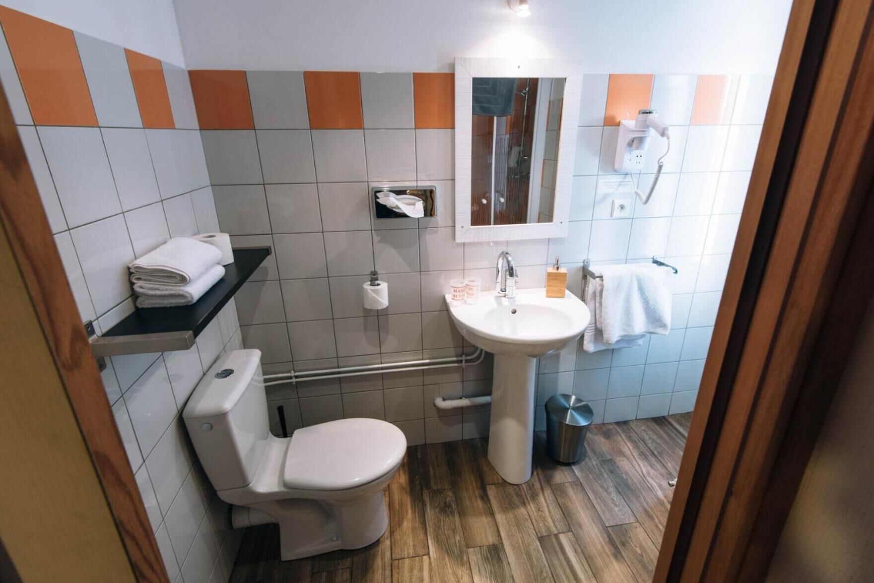 Une salle de bain avec des toilettes, un lavabo et une douche.