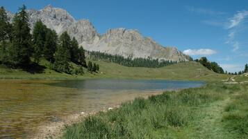 A mountain landscape with a lake and forested hills.