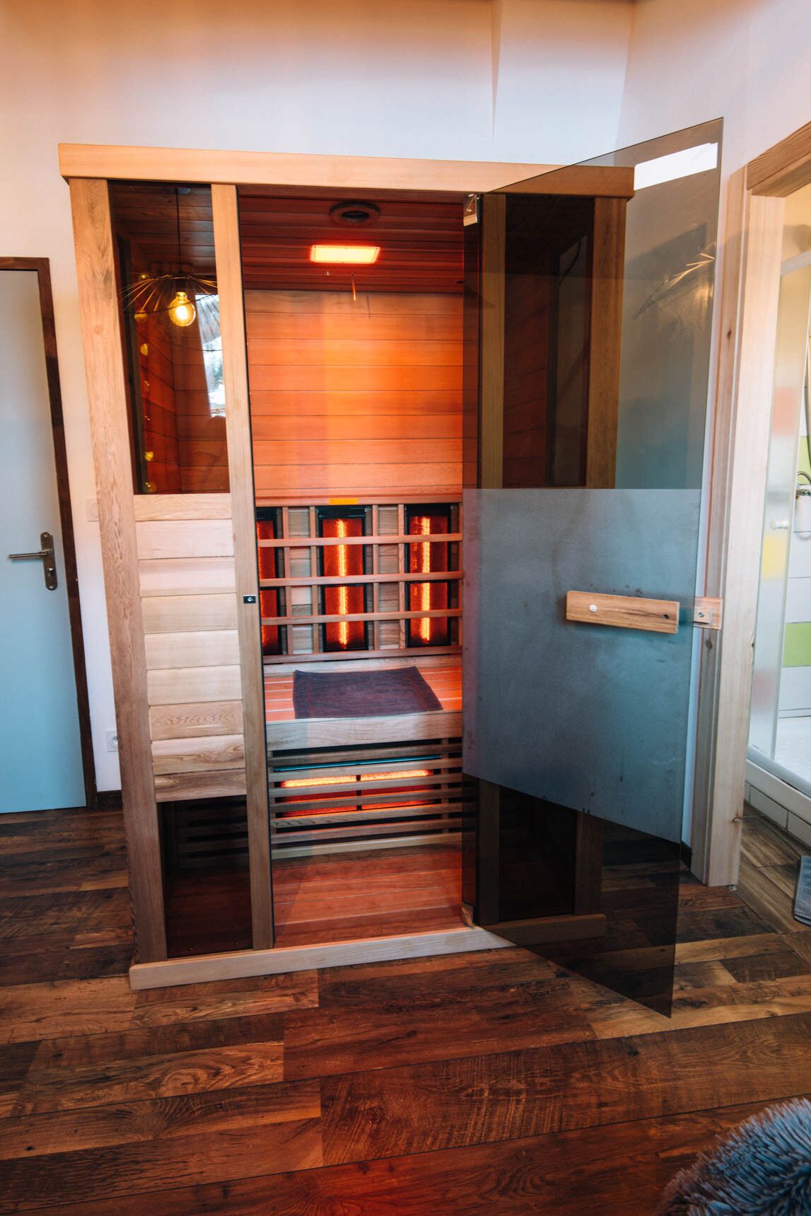 A room with a wooden bench, a door, and a window.