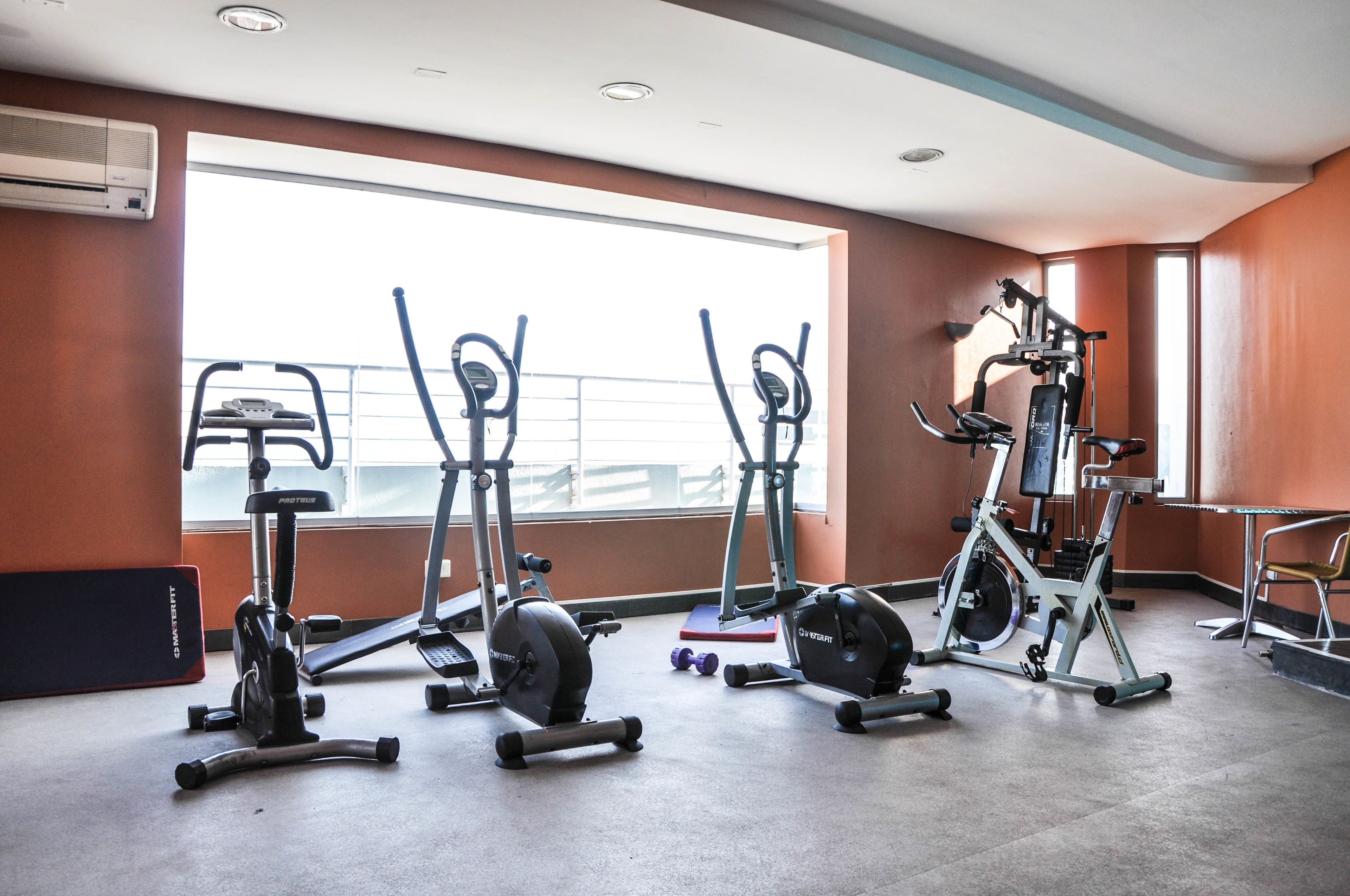 A gym with cardio machines, free weights, and a rowing machine.