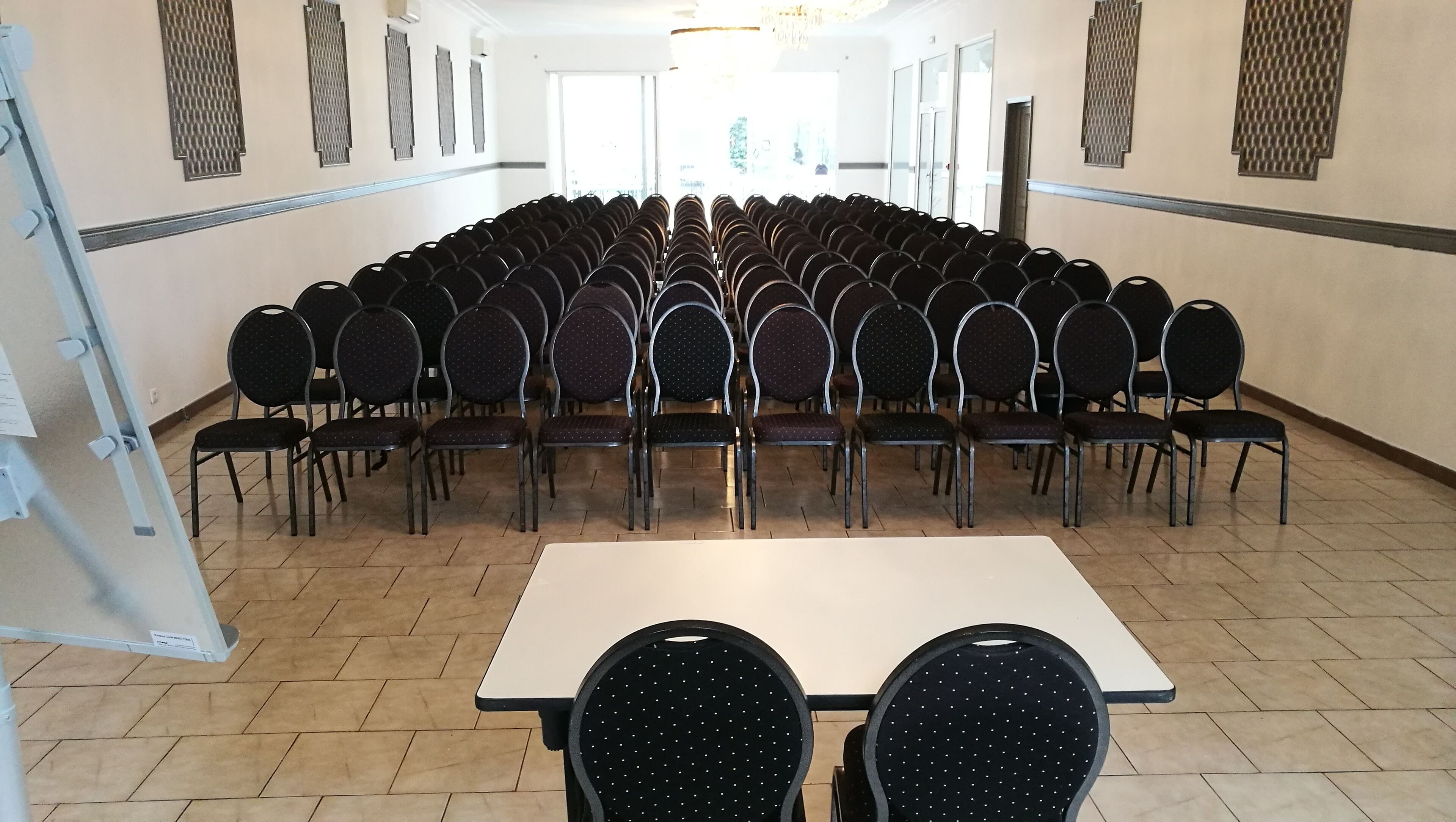 A conference room with rows of chairs and a large table.