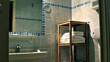 A bathroom with a sink, mirror, and a towel rack.