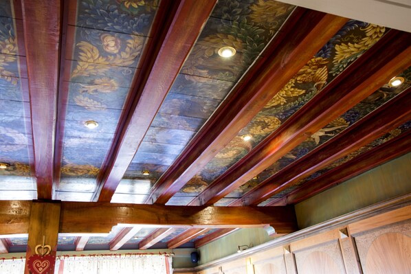 A room with wooden beams and a ceiling painted with floral designs. - Au Chasseur (Sommerau)