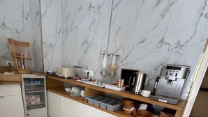 A modern kitchen with marble backsplash, wooden countertop, and built-in appliances. - Hôtel du Parc (Aulnay-sous-Bois)