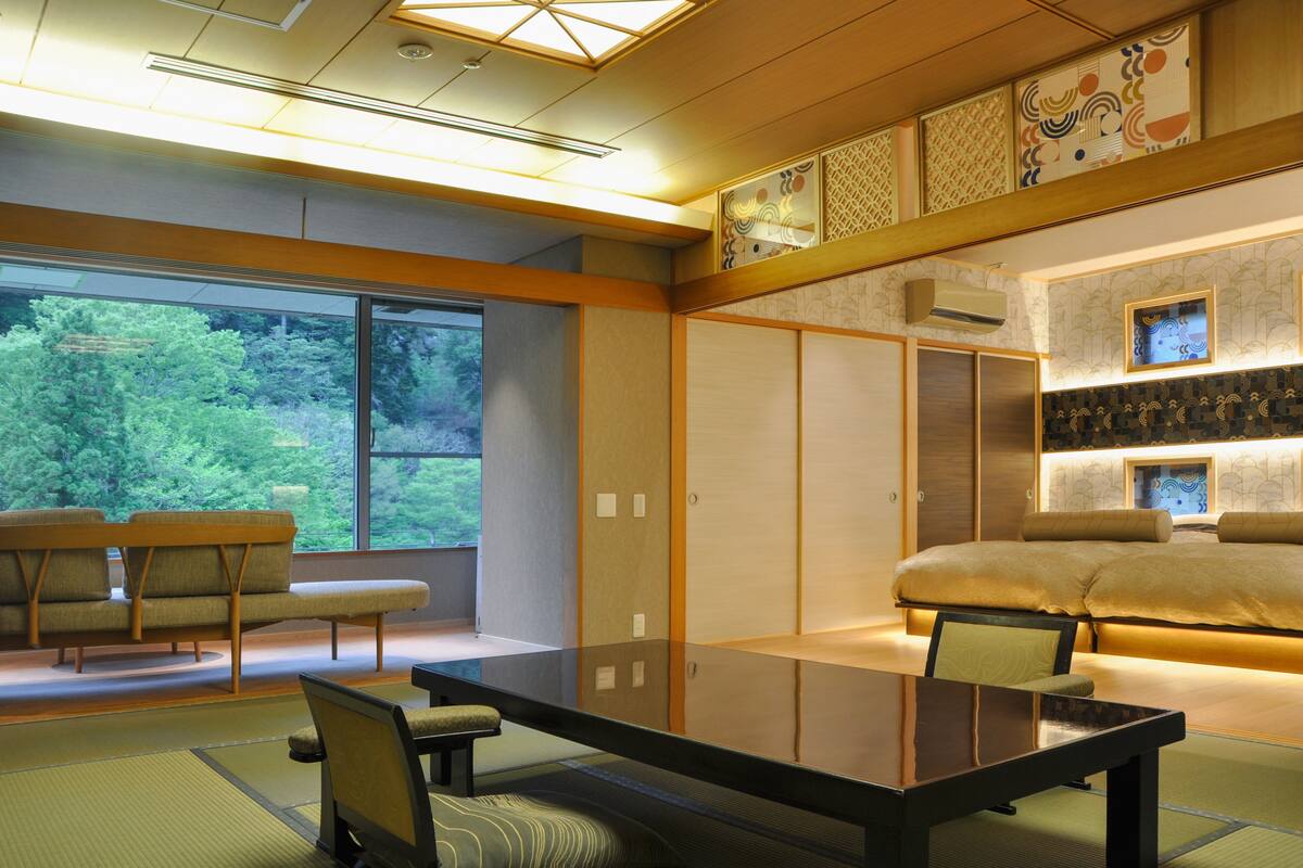 Een traditionele Japanse kamer met tatami vloerbedekking, een lage tafel en een futonbed.