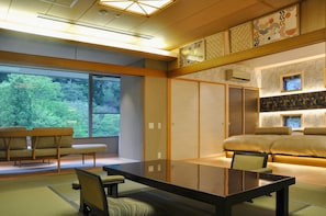 A traditional Japanese-style room with tatami flooring, a low table, and a futon bed.