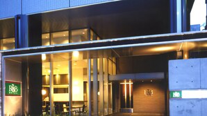 A modern hotel entrance with glass doors, a reception desk, and a sign indicating the name. - R&B Hotel Tokyo Toyo-cho (Tokyo)