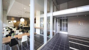 A modern hotel lobby with a long reception desk, glass partitions, and a visible elevator. - R&B Hotel Tokyo Toyo-cho (Tokyo)