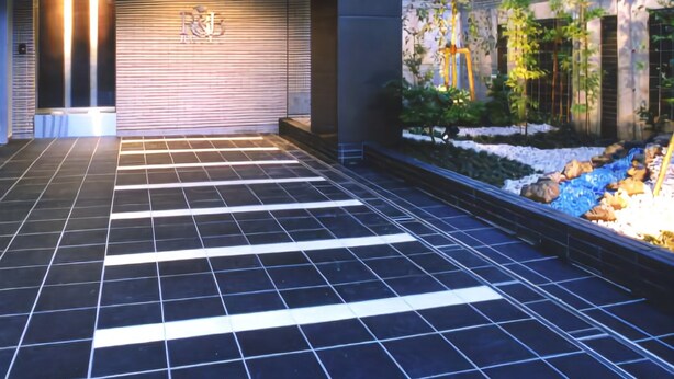 A modern building entrance with a tiled floor and a wall-mounted sign. - R&B Hotel Tokyo Toyo-cho (Tokyo)