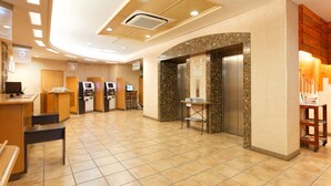 A hotel lobby with a reception desk, seating area, and an elevator. - Washington R&B Hotel Hakata Ekimae Dai 1 (Fukuoka)