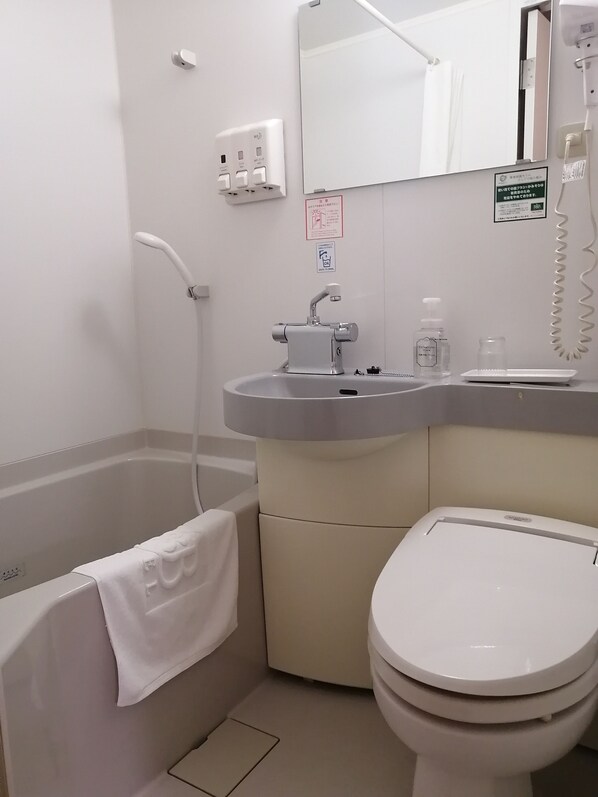A bathroom with a bathtub, a toilet, a sink, and a mirror. - Washington R&B Hotel Hachioji (Hachioji)