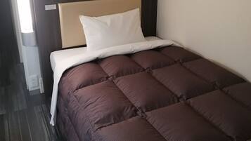 A hotel room with a bed, a headboard, a wall-mounted control panel, and a patterned wall.