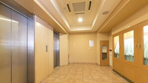 A hallway with a tiled floor, a door with a sign, and a vent on the ceiling. - R&B Hotel Kobe Motomachi (Kobe)