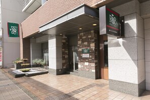 The exterior of R&B Hotel with a stone facade, a covered entrance, and a signboard. - R&B Hotel Kobe Motomachi (Kobe)