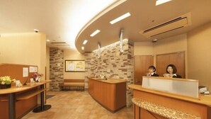 Un área de recepción con un mostrador curvo, una pared de piedra y un banco.