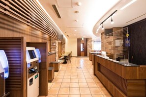 A hotel lobby with a reception desk, seating area, and self-service machines. - Washington R&B Hotel Higashinihombashi (Tokyo)