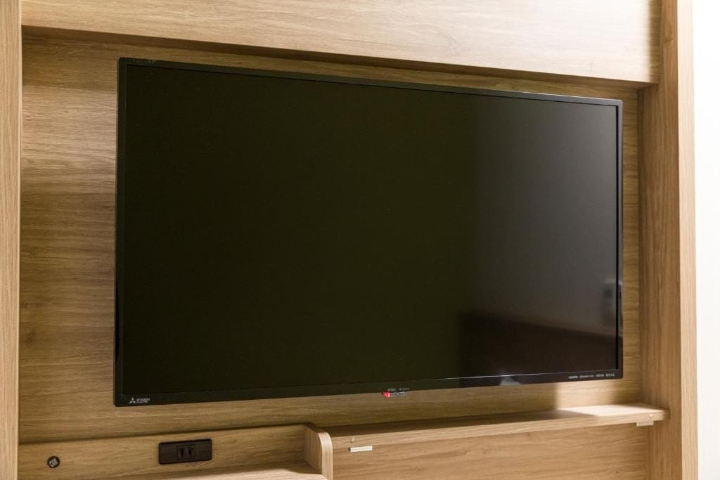 A flat-screen TV mounted on a wooden wall.