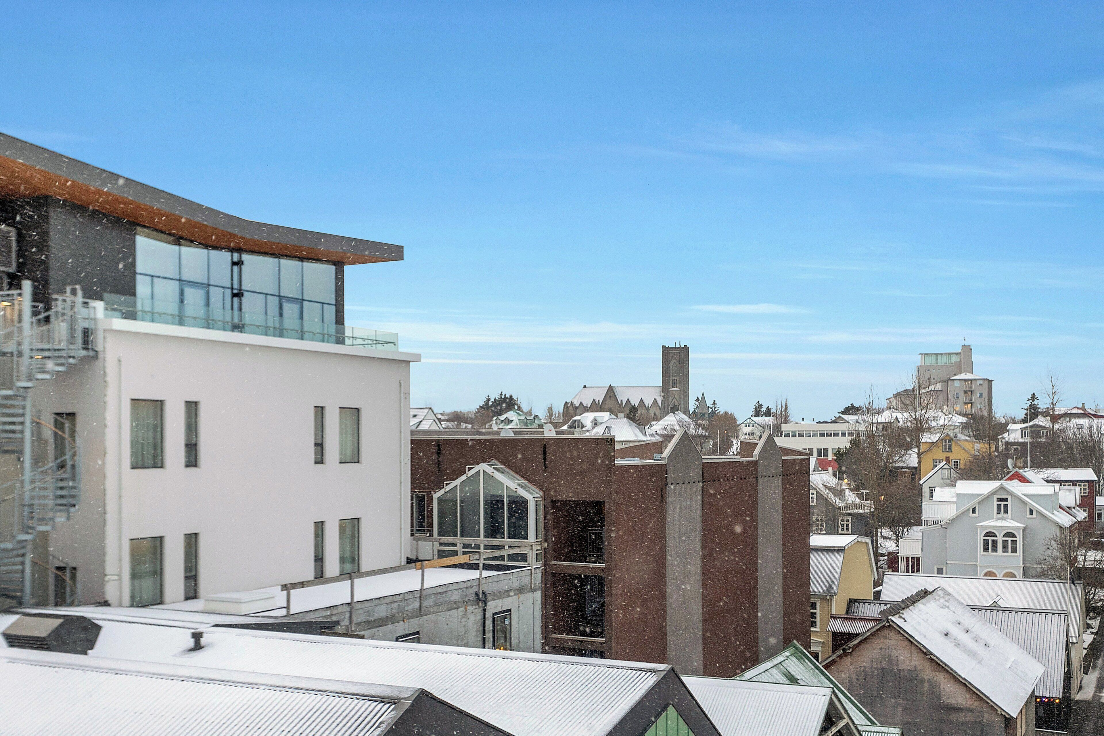 A modern building with a glass facade and a traditional brick structure.