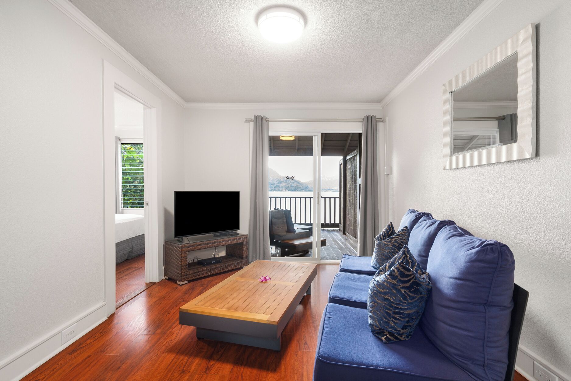 Una sala de estar con televisor, sofá y mesa de centro.