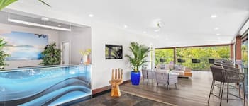A modern interior with a pool, seating area, and large windows.